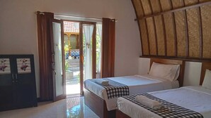 A room with two beds, a wooden ceiling, and a view of a courtyard through an open door. - Ratu Cottage by OurStory Travels (Penida Island)