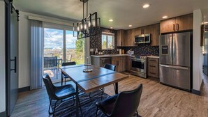A modern kitchen with a dining area, large windows, and a view of the outdoors. - Cozy Air-conditioned Retreat 3 mins from Airport (SeaTac)