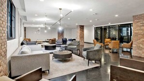 A modern lounge area with sofas, armchairs, and a coffee table. - Beautiful 1 BR Renovated Apt in downtown (Mobile)