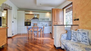 A compact living space with a dining area, kitchenette, and a sofa with a patterned cover. - Gorgeous apartment in Casarza Ligure with WiFi (Casarza Ligure)