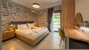 Ein Schlafzimmer mit Steinwand, einem hölzernen Bett, einem Schreibtisch und einem Stuhl.