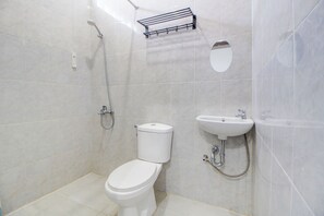 Un baño con inodoro, lavabo y ducha.