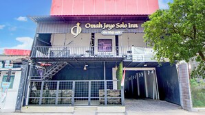 A building with a sign reading "Omah Joyo Solo Inn" and a staircase leading to an upper level. - Collection O Omah Joyo Solo Inn Near Keraton Surakarta (Surakarta)