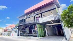 A building with a sign reading "Omah Joya Solo Inn" and "the klogi cafe". - Collection O Omah Joyo Solo Inn Near Keraton Surakarta (Surakarta)