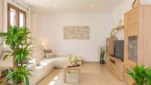 A modern living room with a sofa, coffee table, TV, and potted plants. - Villa Placeta - Villa With Private Pool. Free Wifi (, Illes Balears)