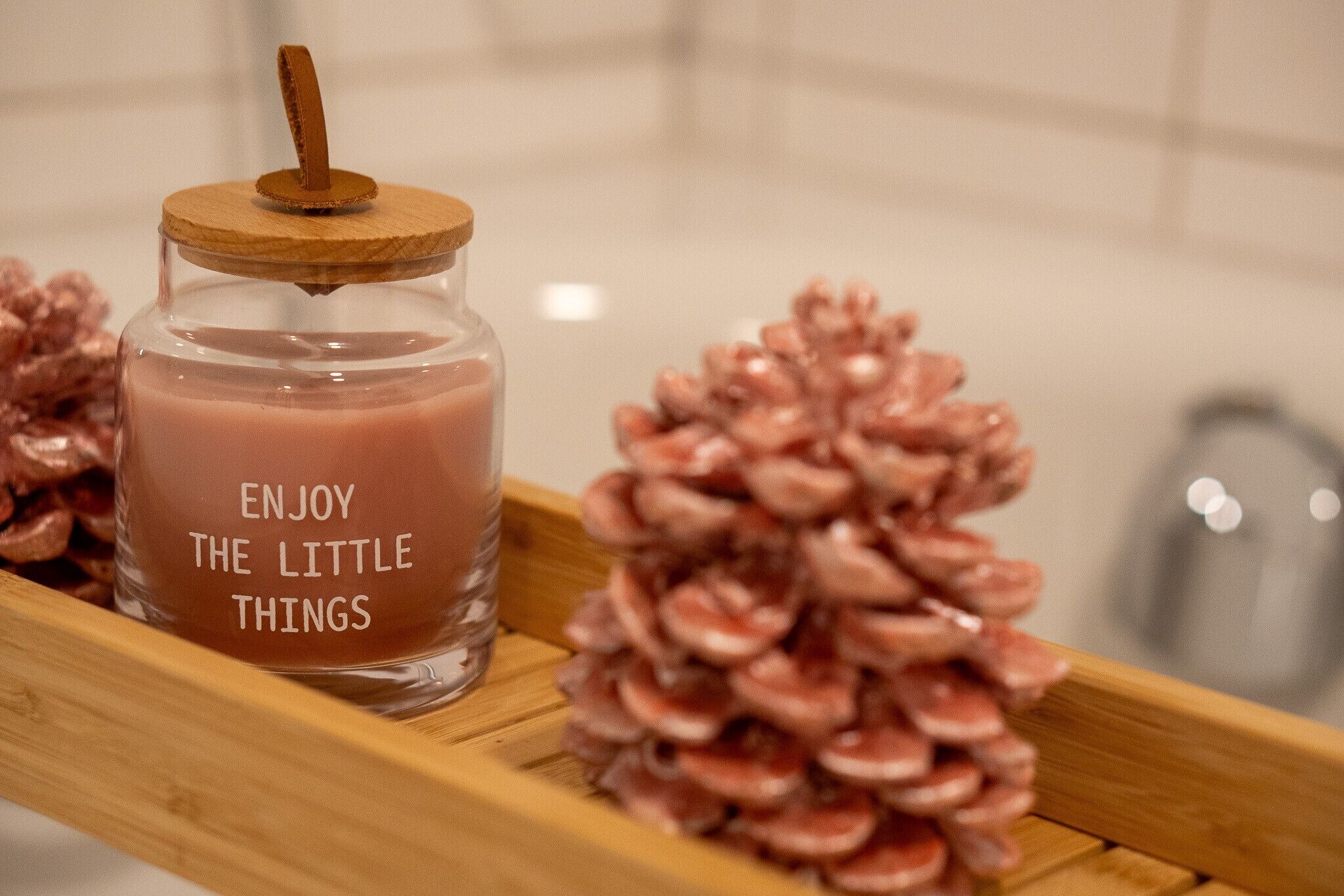Een glazen pot met een houten deksel en een etiket waarop staat 'ENJOY THE LITTLE THINGS'.