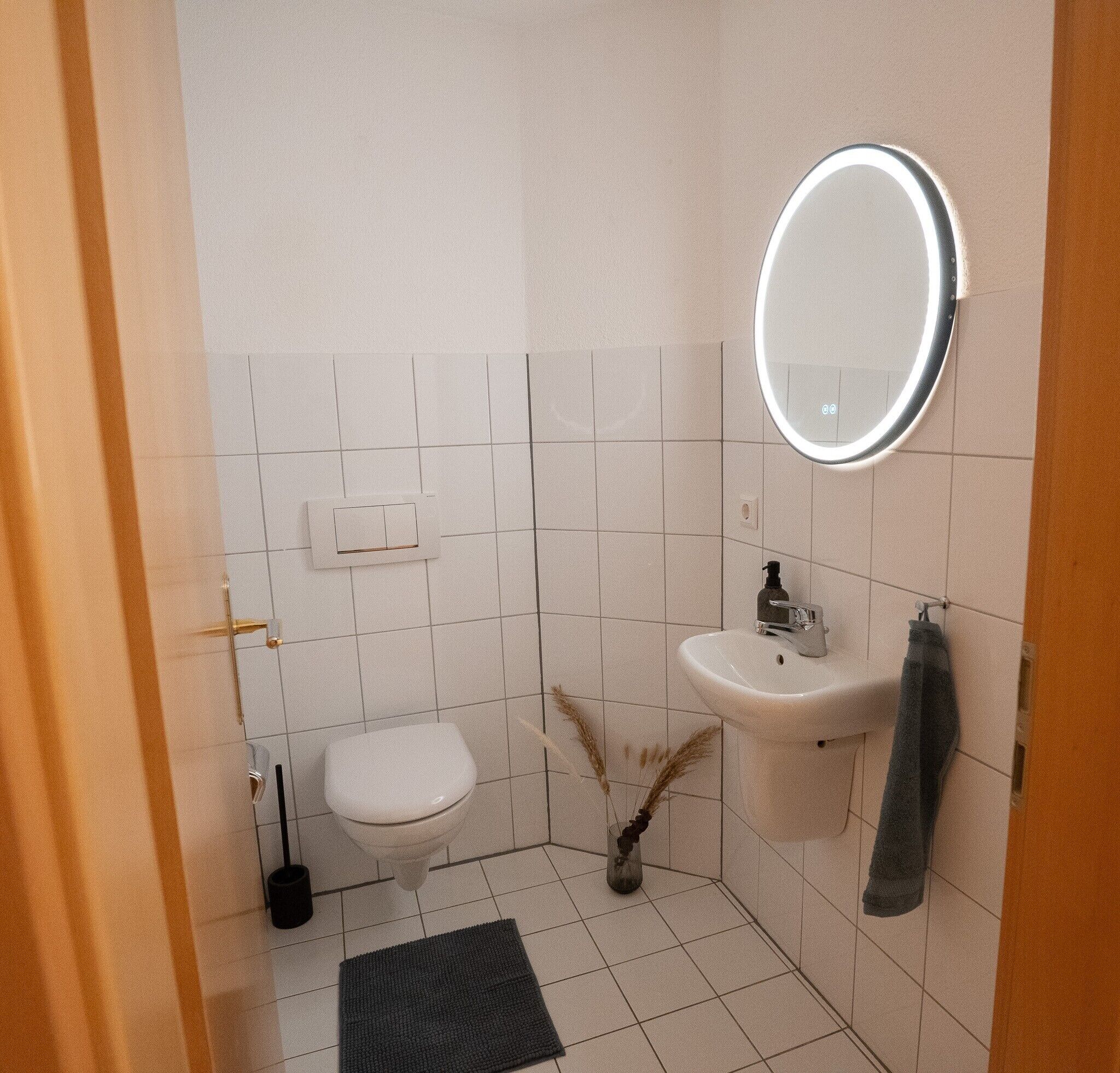 Ein Badezimmer mit Toilette, Waschbecken, Spiegel und Handtuchhalter.