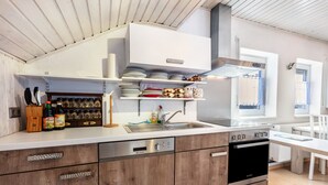 Una cocina moderna con armarios de madera, lavavajillas y horno empotrado.