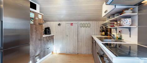 Eine moderne Küche mit Edelstahlgeräten, Holzschränken und einem Schild mit der Aufschrift 'HOME'.