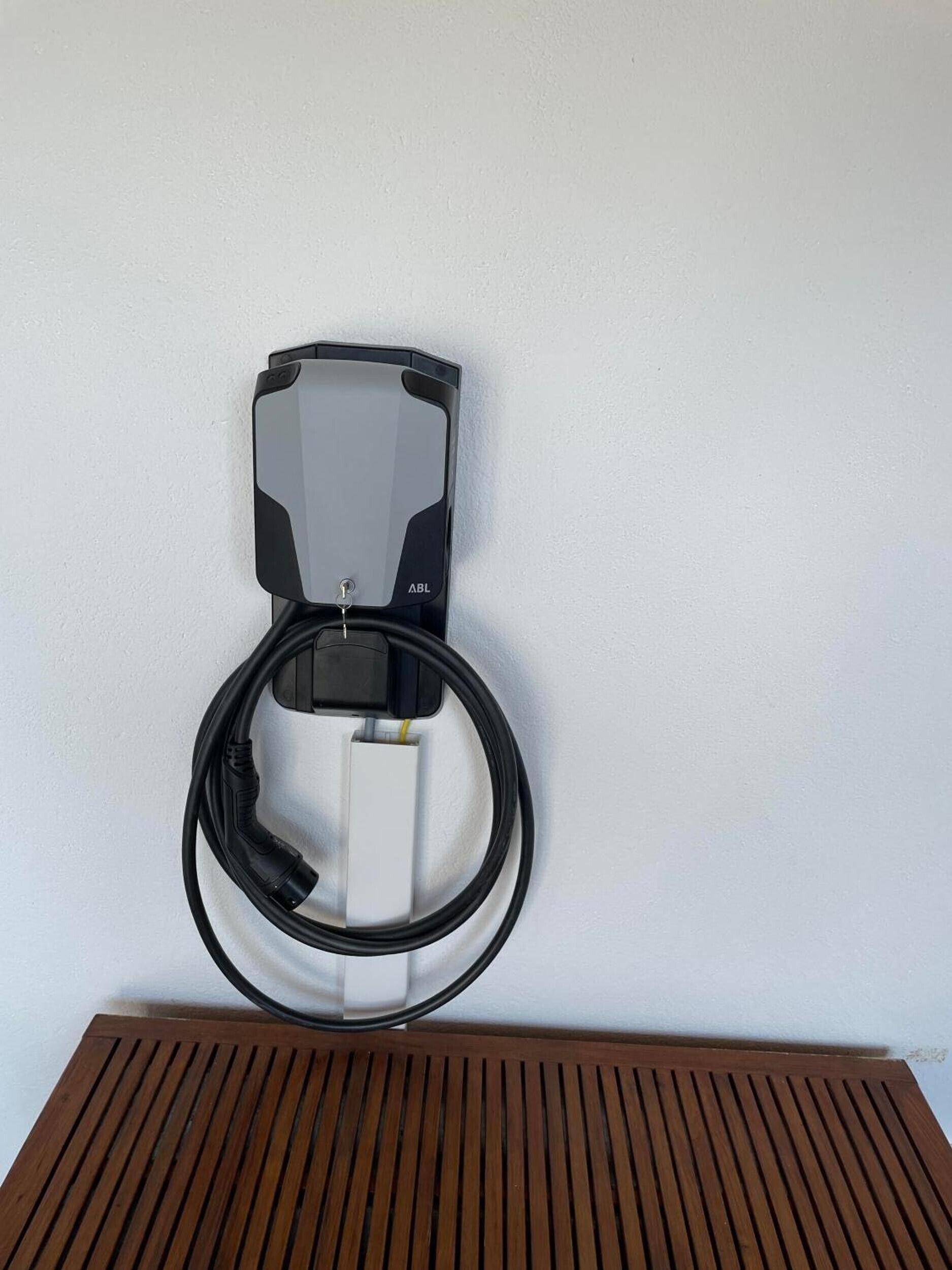 Eine an der Wand montierte Ladestation mit Kabel.