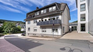 Un immeuble de deux étages doté d’un balcon au deuxième étage, d’une allée et donnant sur la rue.