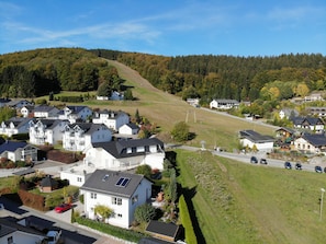 Un barrio residencial con casas, una carretera y una colina al fondo.