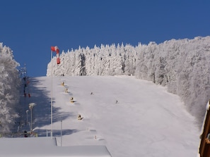 Una pista de esquí nevada con un telesilla y árboles.