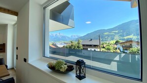 A room with a large window overlooking a mountainous landscape.