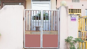 A gated entrance with a metal gate, a small window, and a wall-mounted sign. - Hotel Shivangi Eco TripandTrip (Puri)