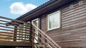 Een houten vakantiehuisje met een houten trap naar een raam.