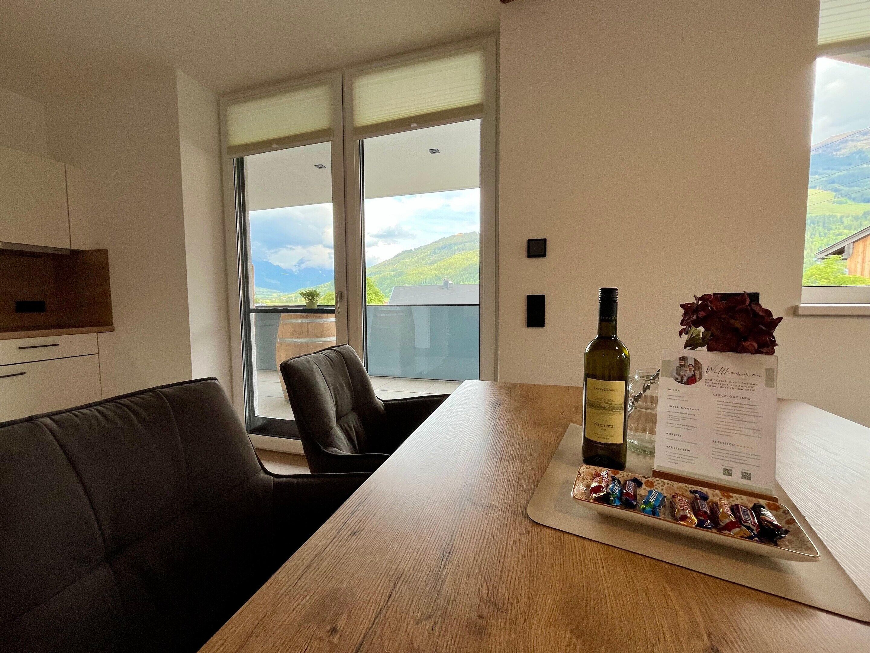 Quarto moderno com mesa de madeira, uma garrafa de vinho e um menu sobre a mesa.
