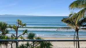 Een strand met palmbomen en uitzicht op de oceaan.