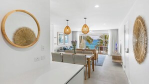 Een moderne keuken met een eetgedeelte, met een groot raam en uitzicht op de oceaan.