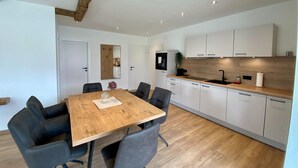 A modern kitchen with white cabinets, a wooden countertop, and a built-in oven. - Apartment in Saalfelden Near Ski Slopes (Saalfelden am Steinernen Meer)