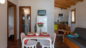 Un ambiente compatto con zona pranzo, angolo cottura e salottino.