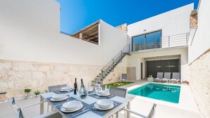 A modern outdoor dining area with a pool and a staircase leading to a second floor. - Ca Na Foc - Villa With Private Pool In Sa Pobla (Sa Pobla, Illes Balears)