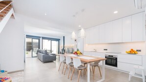 A modern kitchen with white cabinets, a wooden dining table, and a built-in oven. - Ca Na Foc - Villa With Private Pool In Sa Pobla (Sa Pobla, Illes Balears)