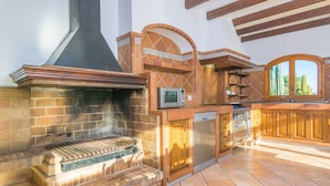 Una cocina con una parrilla empotrada, microondas, lavavajillas y armarios de madera.