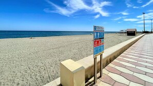 A beach with a signboard displaying usage and access rules.