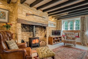 Relax in this inviting living room with a fireplace, comfortable armchair, and large window.