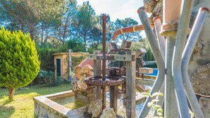 A rustic outdoor water feature with a wooden structure, a metal pump, and a stone basin. - Els Pins - Villa With Private Pool In Crestatx (Crestatx , Illes Balears)