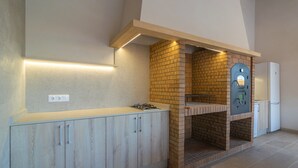Een keuken met een ingebouwde bakoven, houten kastjes en een witte koelkast.