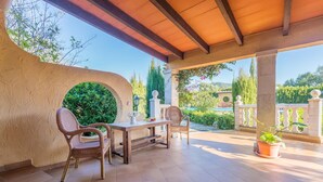 An outdoor patio with a wooden table and wicker chairs, surrounded by a stone wall and potted plants. - Hibiscus - Villa With Private Pool In Crestatx (Crestatx , Illes Balears)