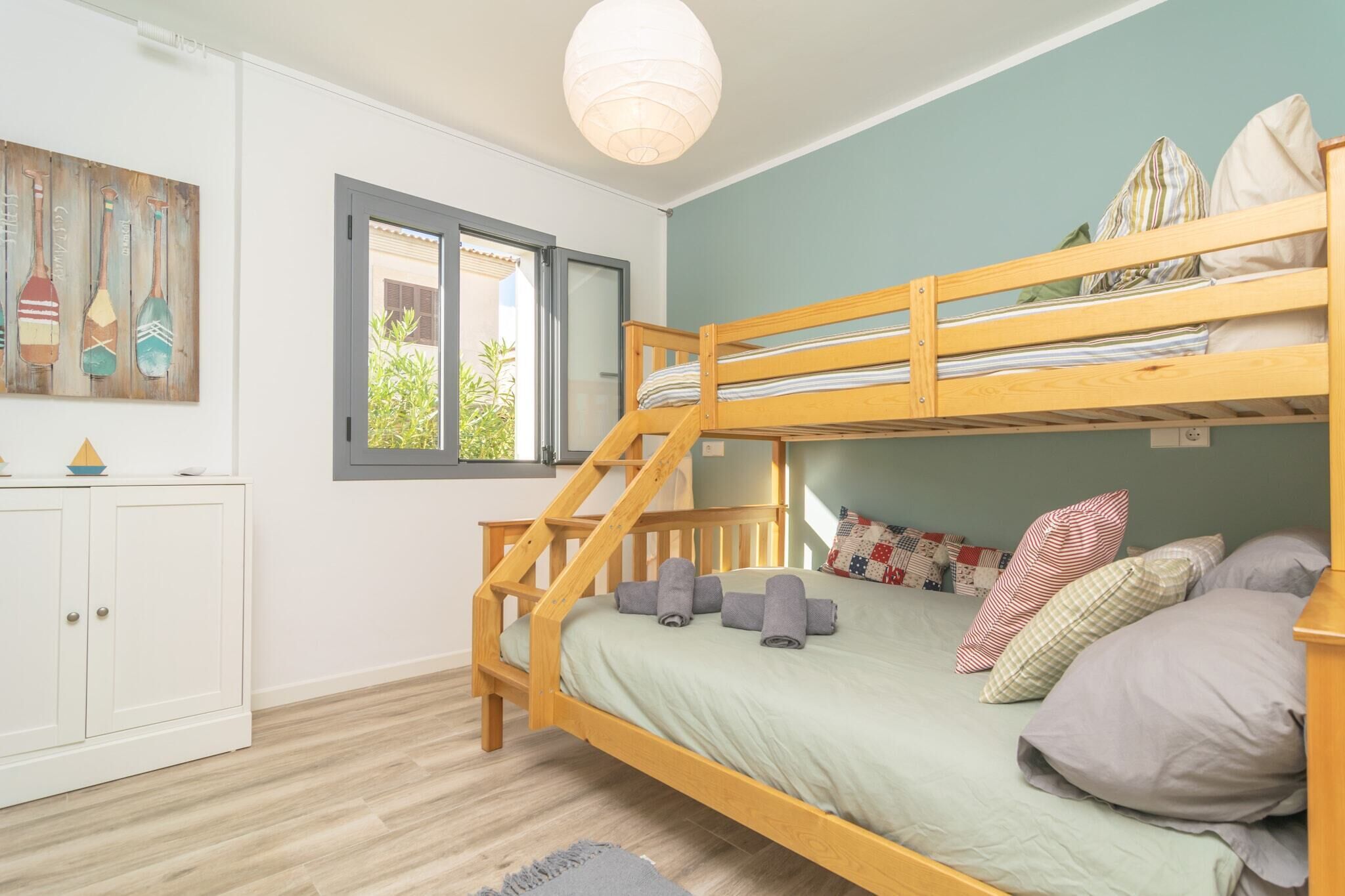 A bunk bed room with a staircase, a window, and a cabinet.
