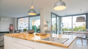 Una cocina moderna con encimera de madera, un lavamanos y luces colgantes.