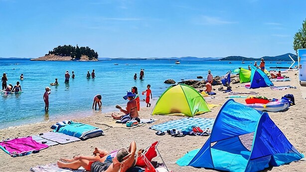 A beach with tents, people swimming, and a clear sky. - Vacation home Golem by Interhome (Pakoštane)