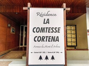 Schild für 'Residence LA COMTESSE CORTENA' mit Wegweisern zu Eingang B (Nr. 322) und Eingang A (Nr. 294).