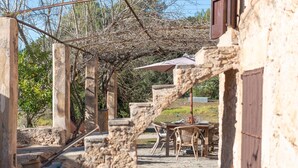 A rustic outdoor dining area with stone columns, a pergola, and a table set for two. - Son Pastor - Villa With Private Pool In Artà (, Illes Balears)