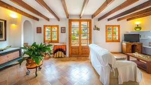 Una habitación acogedora con vigas de madera, una cama, un televisor, una mesa y una planta en maceta.