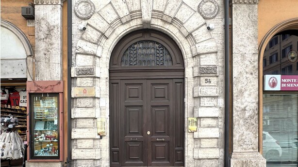 A stone facade with a large, dark wooden door, numbered 54, flanked by two columns. - Peace window, al centro del centro di Roma e d'Italia (Roma)