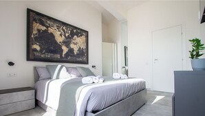 A modern bedroom with a large bed, a world map artwork, a grey dresser, and a potted plant. - Peace window, al centro del centro di Roma e d'Italia (Roma)