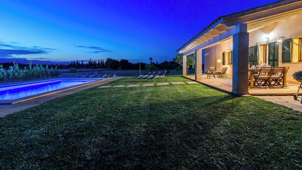 Ein modernes Haus mit Pool, Sitzgelegenheit im Freien und Bergblick.