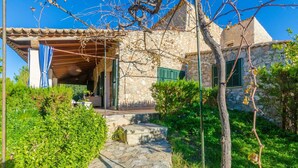 A stone building with a tiled roof, a covered entrance, and a stone staircase leading to the door. - Can Reure (can Paris) - Villa With Private Pool (Inca, Illes Balears)