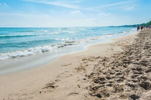 A sandy beach with footprints, calm waves, and a clear sky. - Riandgo - Apartment In Port D'alcúdia. Free Wifi (Port D'alcúdia, Illes Balears)