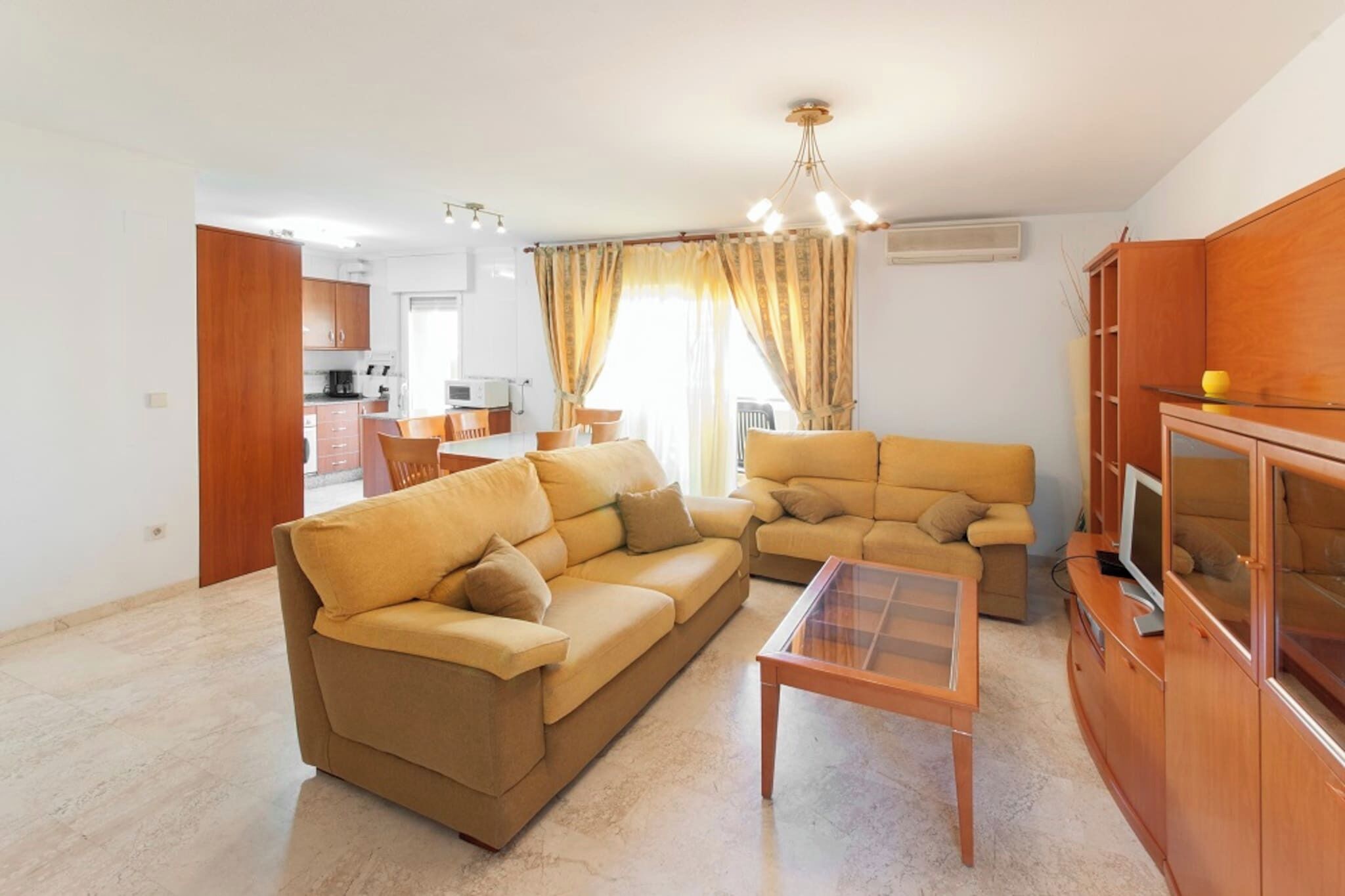 Una sala de estar con dos sofás, una mesa de centro y un mueble para televisión.