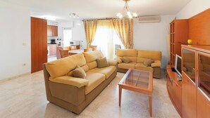 A living room with two sofas, a coffee table, and a TV stand. - Cascades - Apartment In Dénia (Denia, Alicante)