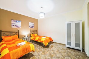 Et hotelværelse med to senge, et skab og en loftlampe.