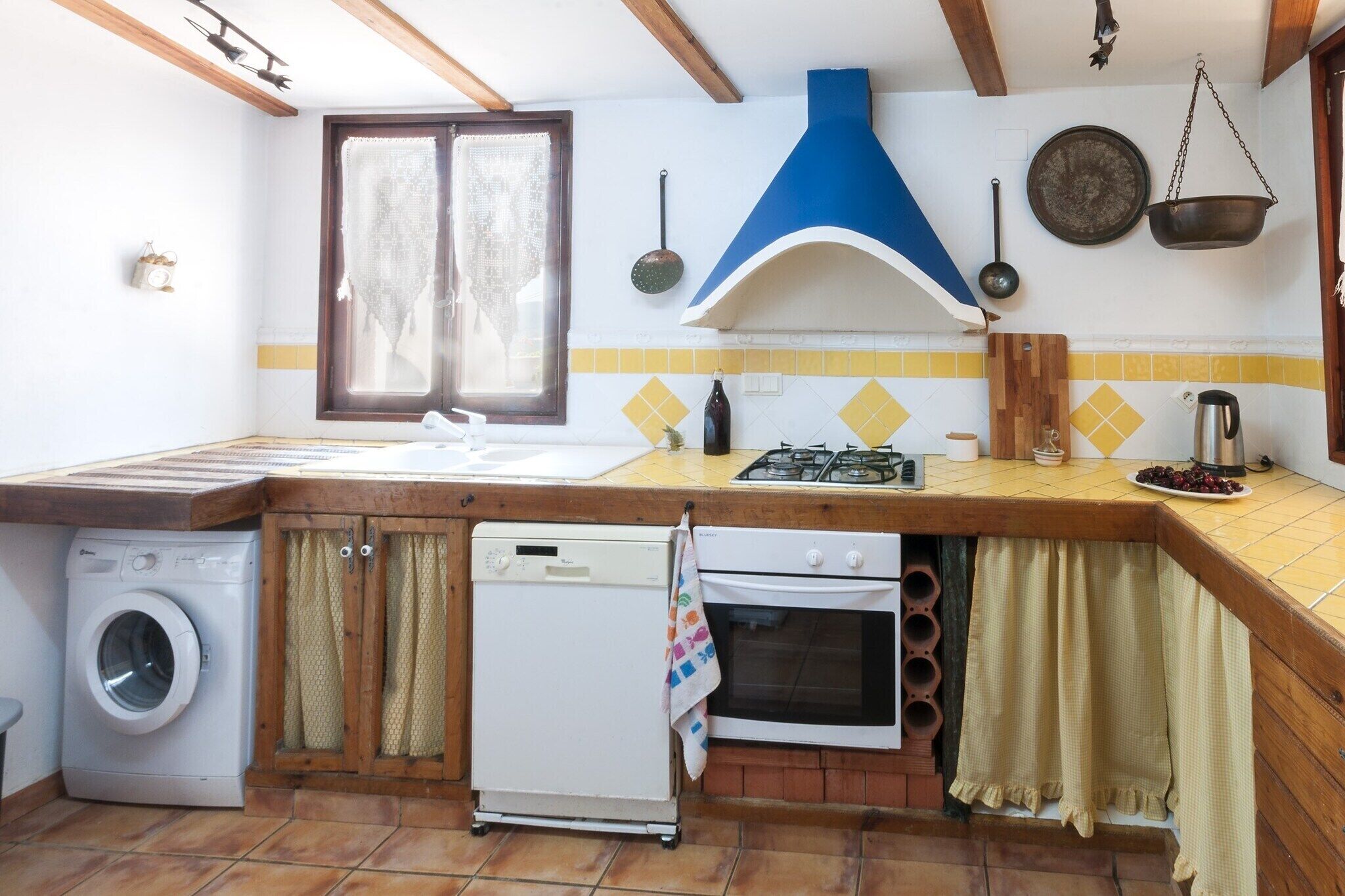 Una cocina compacta con lavadora, lavavajillas, estufa y fregadero.