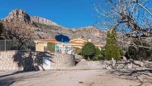 A building with a stone wall and a metal fence in front. - Portilet - Villa With Private Pool In Barx (Barx, Valencia)