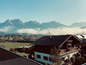 A mountain village with traditional wooden houses, a clear sky, and a view of snow-capped mountains. - Apartment in Saalfelden With Panoramic View (Saalfelden am Steinernen Meer)